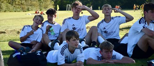 Drengenes fodboldhold ligger og slapper af på en græsplæne