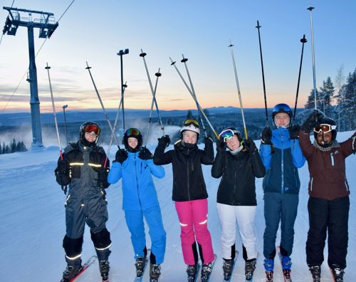6 elever fra Sædding Efterskole på skitur. Alle har stavenen løftet over hovedet. 