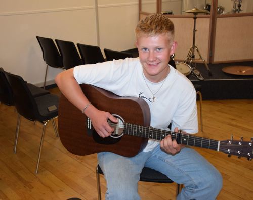 Efterskoledreng sidder med guitar til guitarundervisning på Sædding Efterskole