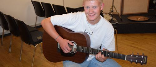 Efterskoleelev spiller akustisk guitar
