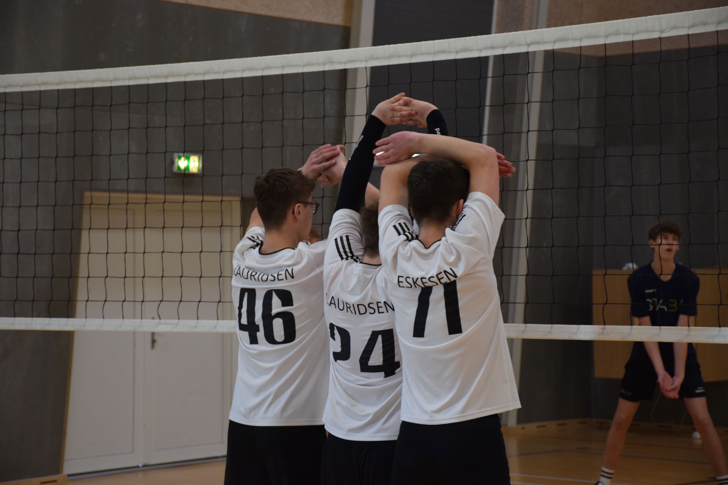 Volley Sædding Efterskole | Tre drenge står ved nettet til et volleystævne