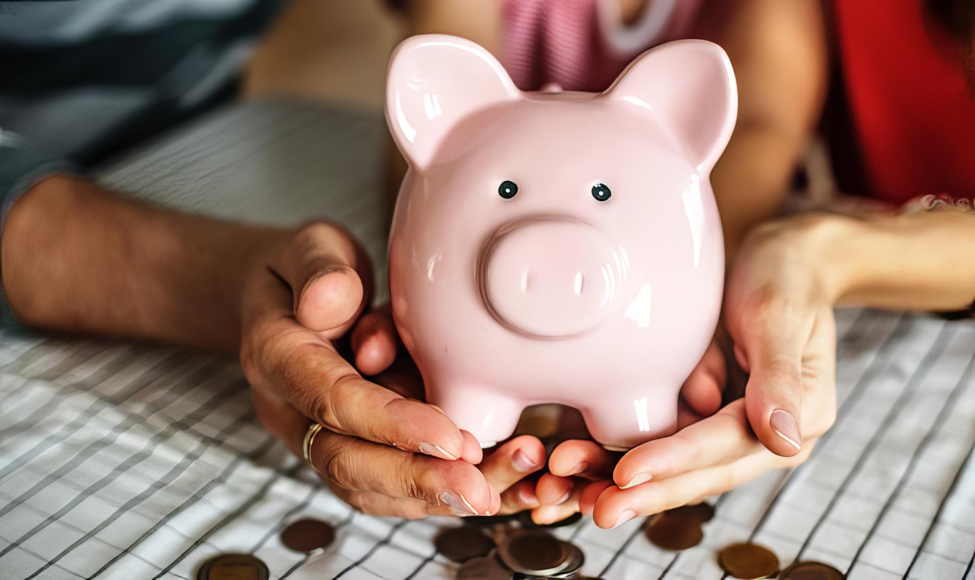 Kvinde sidder med sparegris i hænderne