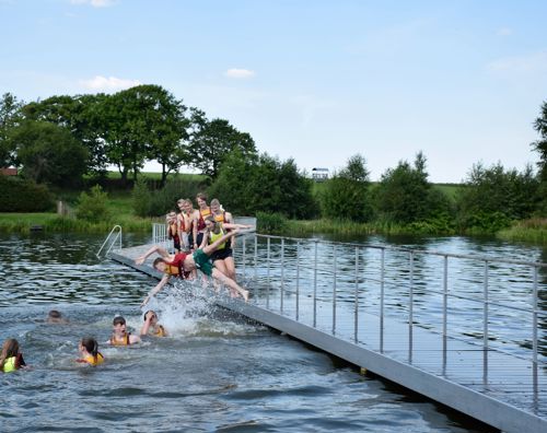 Tæt på Sædding Efterskole ligger Rækker mølle badesø, som vi ofte benytter. Her springer eleverne glade i søen.