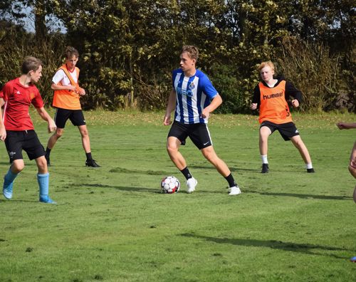 Fodbold Sædding Efterskole | Efterskoleelev dribler i en fodboldkamp på Sædding Efterskole