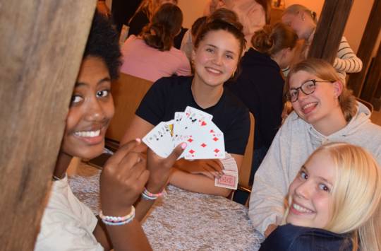 pige- og drengetur på Sædding Efterskole. Her sidder en flok piger og spiller kort og hygger sig 