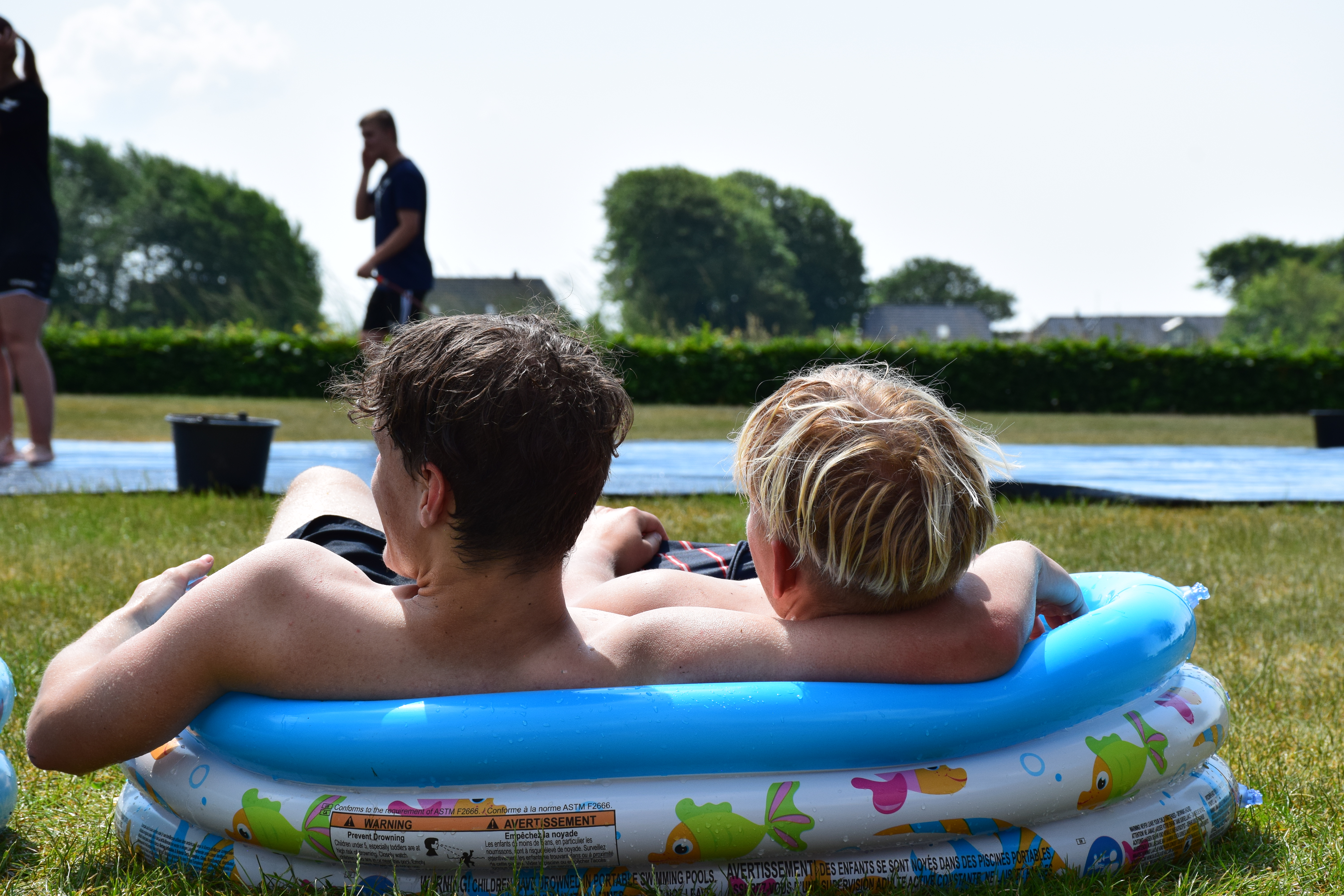 To efterskoledrenge sidder i et lille badebassin i haven på Sædding Efterskole 