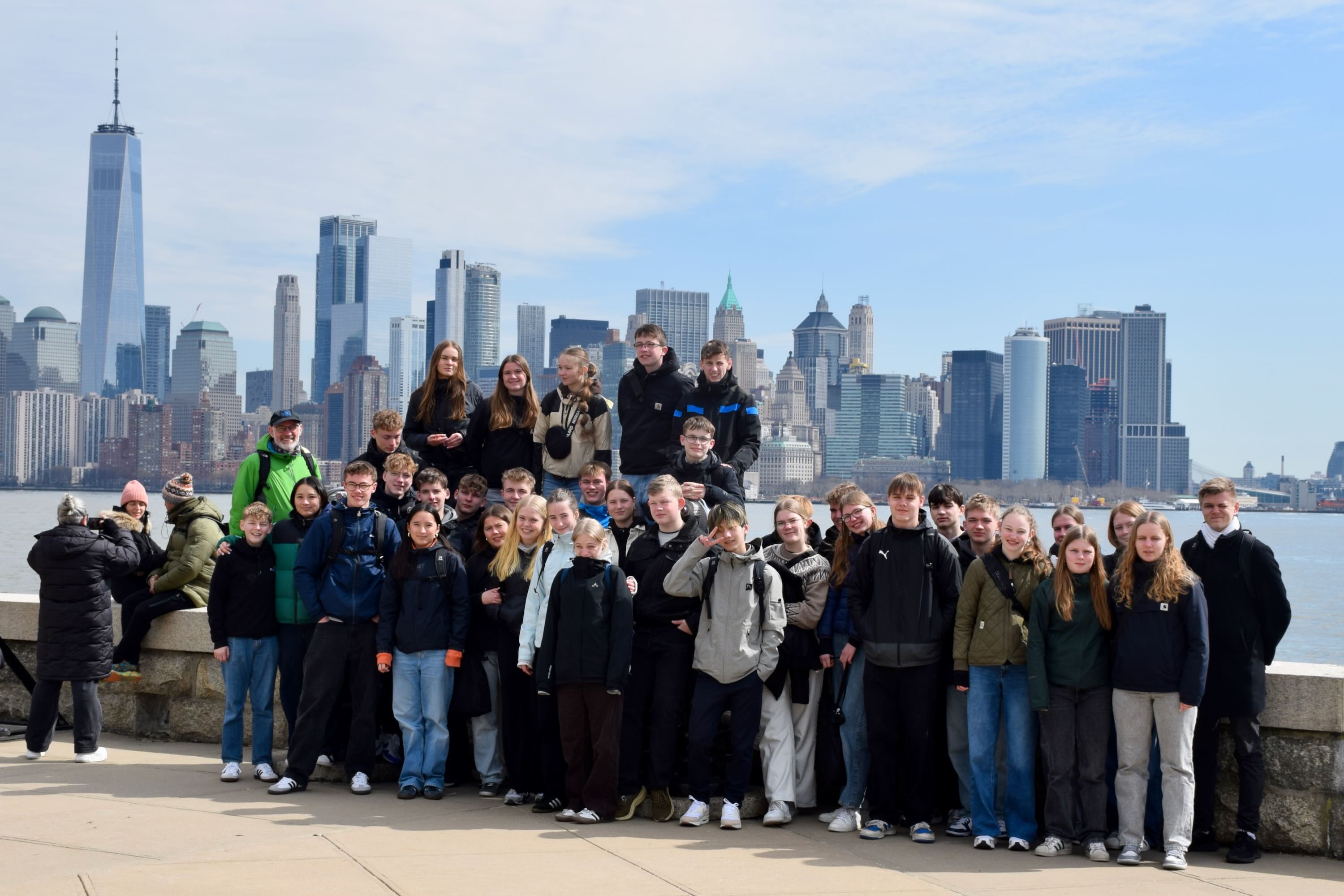 World Wide linjen fra Sædding Efterskole står i en gruppe med New York og dens højhuse i baggrunden. 