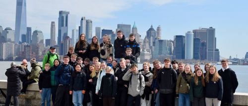 World Wide linjen fra Sædding Efterskole står i en gruppe med New York og dens højhuse i baggrunden. 