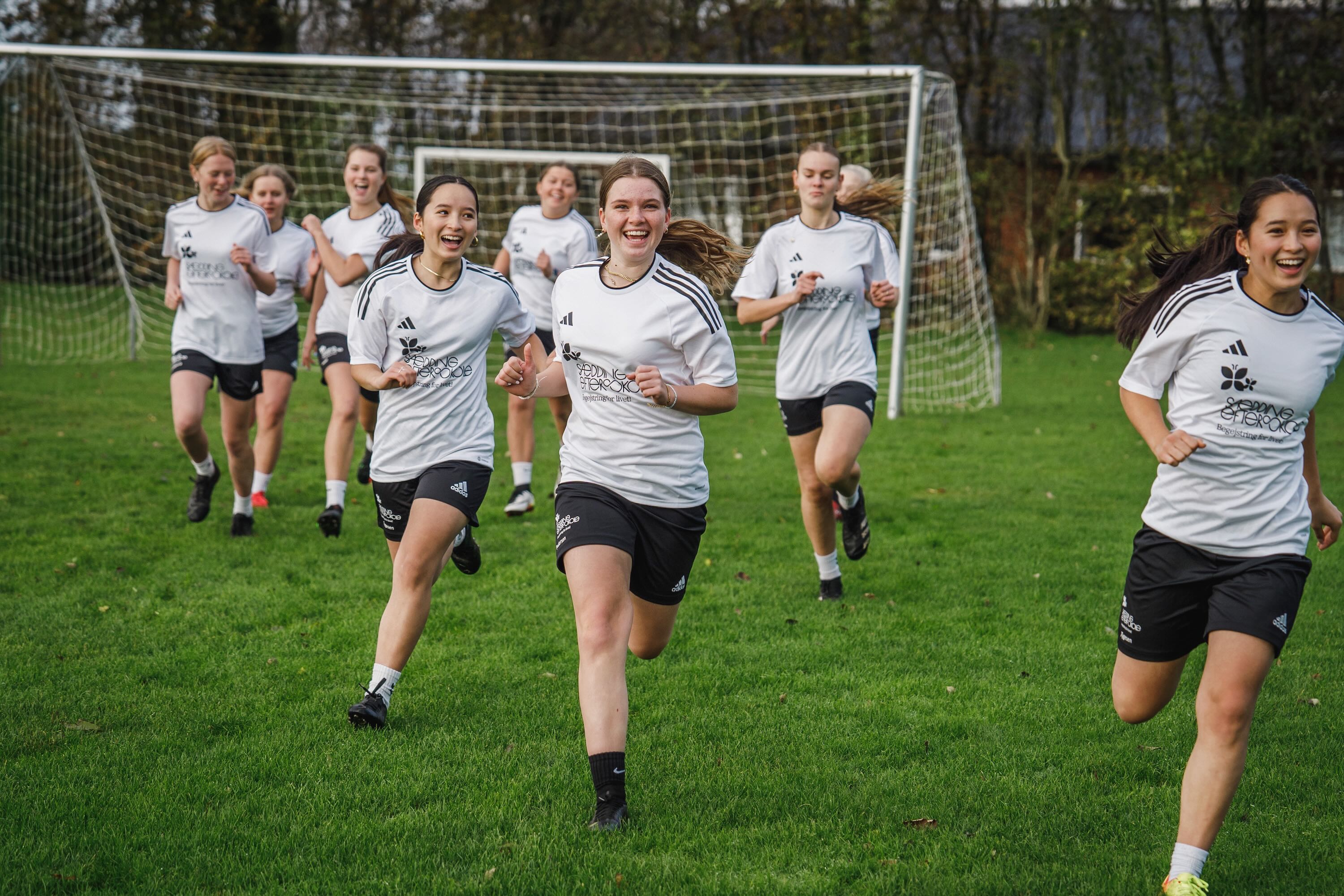 Sædding Efterskoles pigehold laver opvarmning på fodboldbanen