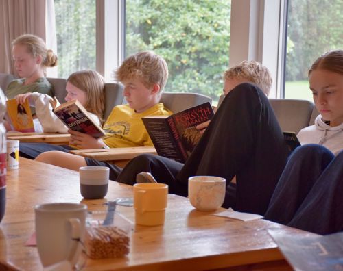 Undervisning på efterskole. Efterskoleelever sidder i dagligstue på Sædding Efterskole og læser i bøger.