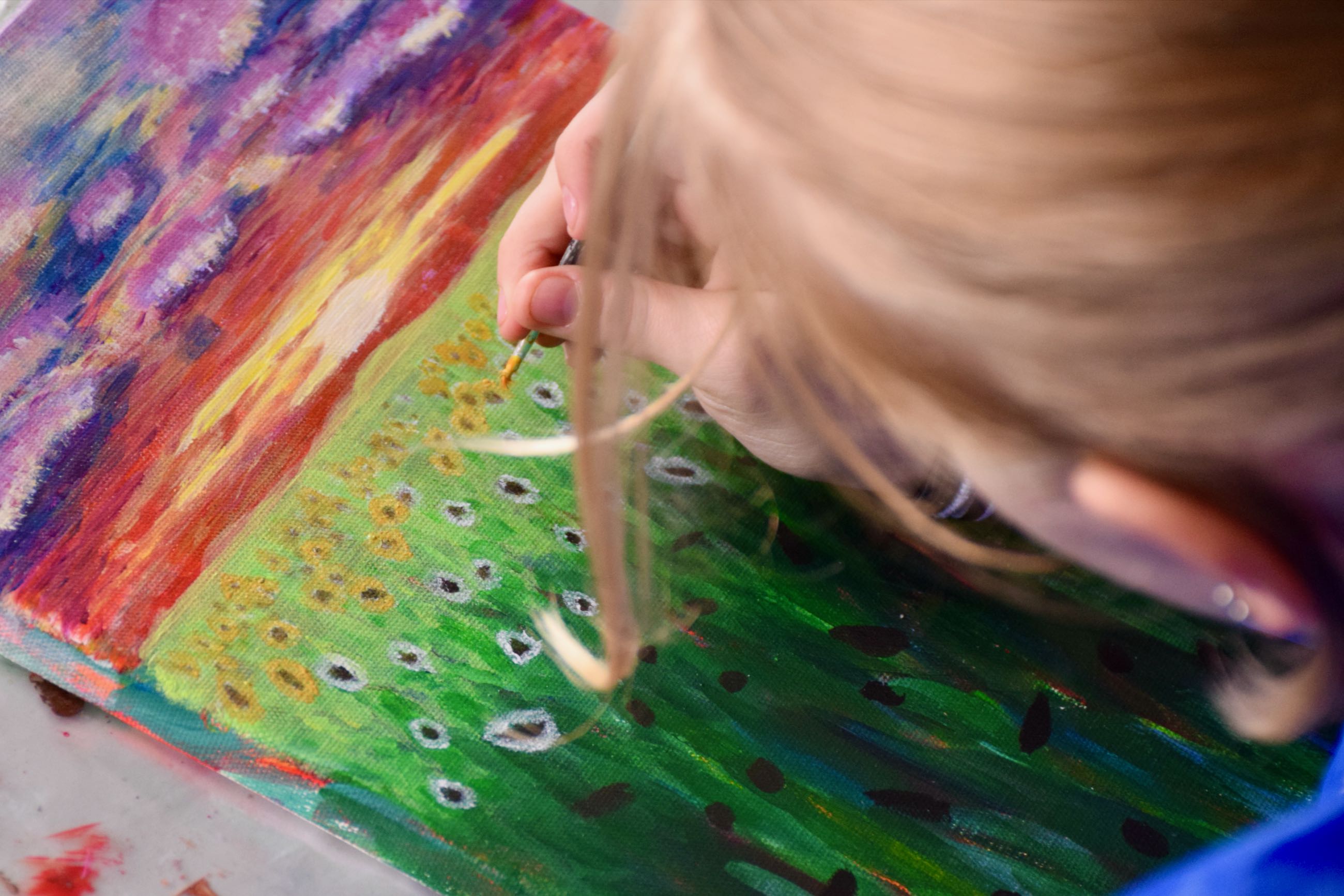 Kreativ Sædding Efterskole | Efterskolepige maler et billede af en blomstermark i det kreative lokale på Sædding Efterskole