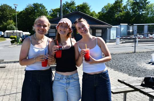 Afslutningstur med Sædding Efterskole på Mørkholt Camping | Tre efterskolepiger står med Sluch ice og smiler. 