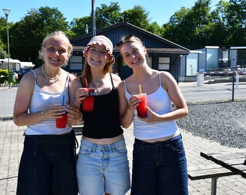 Afslutningstur med Sædding Efterskole på Mørkholt Camping | Tre efterskolepiger står med Sluch ice og smiler.