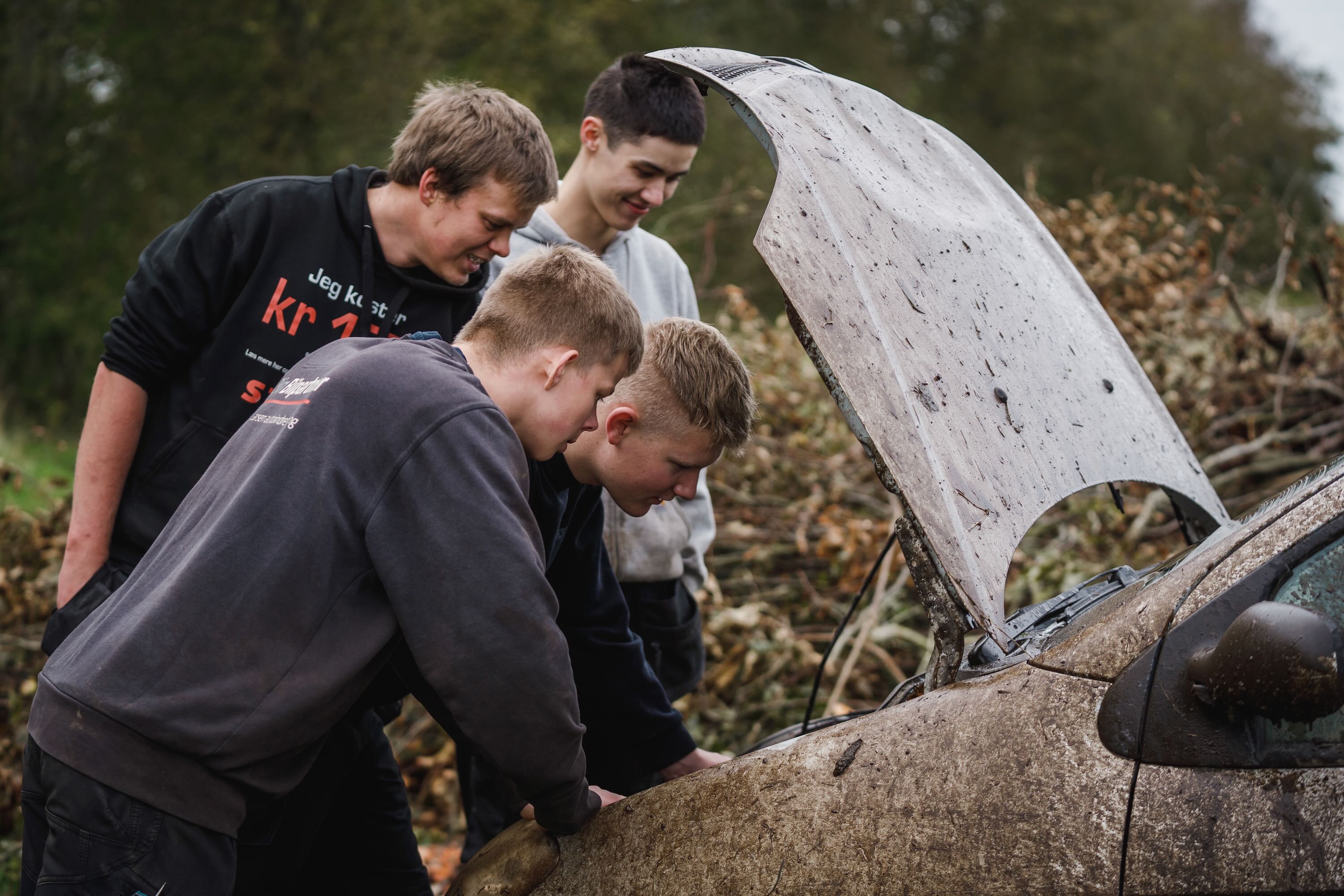 Motorlære Sædding Efterskole | Efterskoleelever ser i motoren på en markræs bil