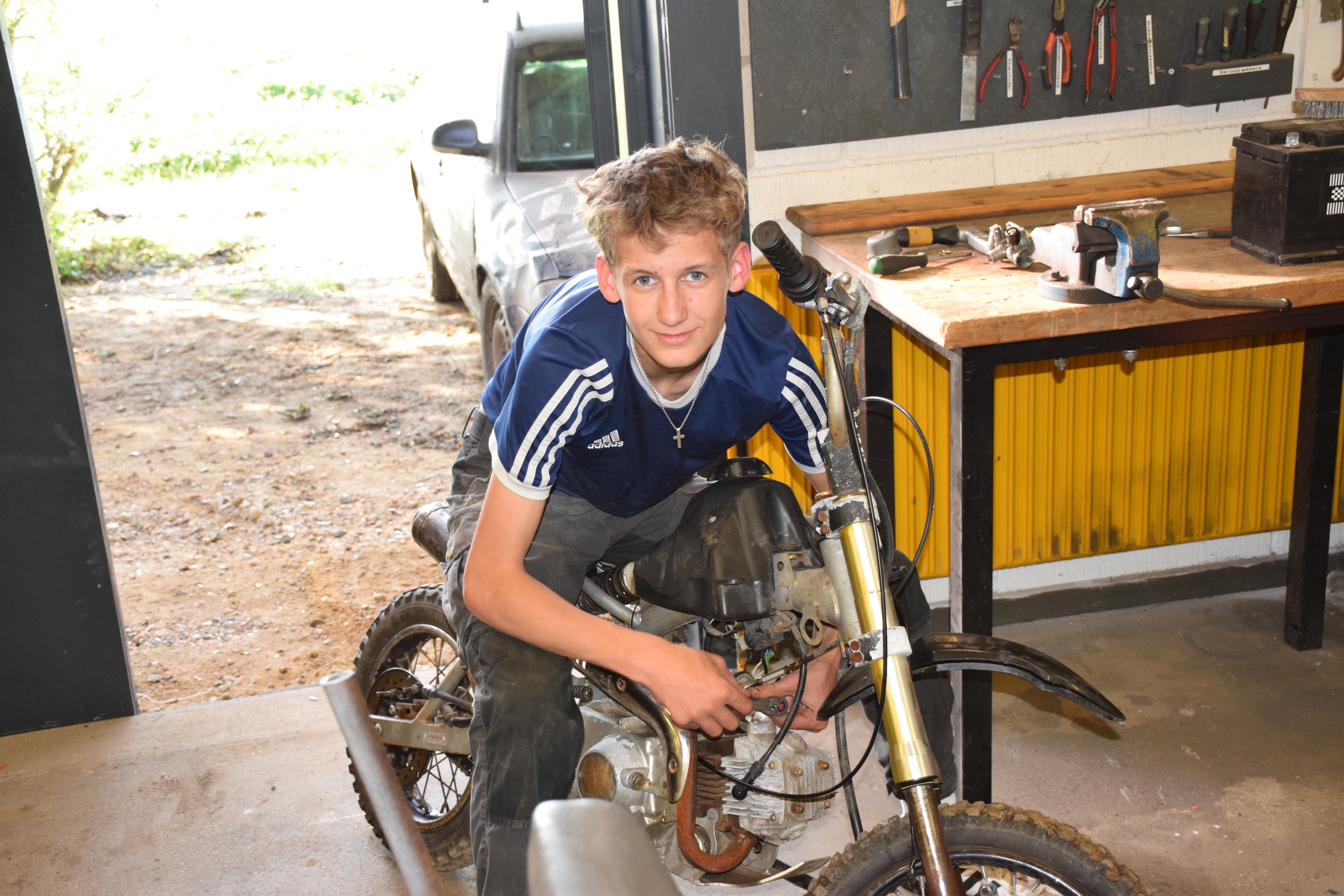 Efterskolernes dag. En dreng sidder på sin knallert og er ved at fikse den i motorværkstedet på Sædding Efterskole 
