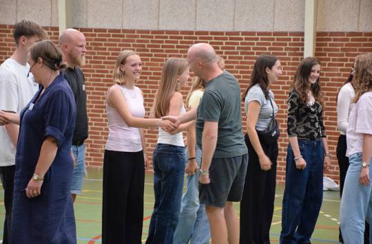 Elever og lærere fra Sædding Efterskole hilser på hinanden på årets første skoledag. 