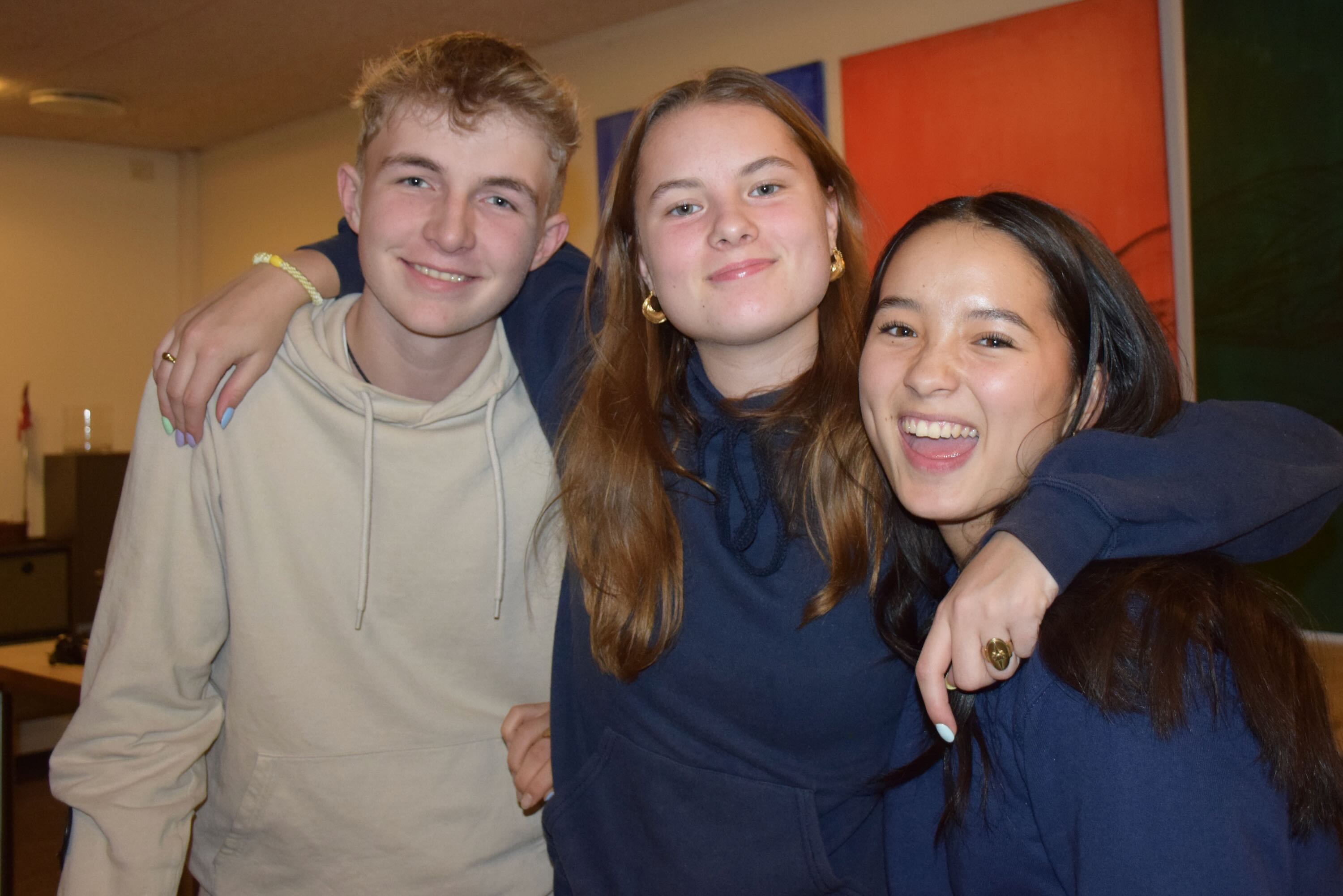 Sædding Efterskole | Tre efterskoleelever står en aften med armene rundt om hinanden i spisesalen på Sædding Efterskole. De smiler