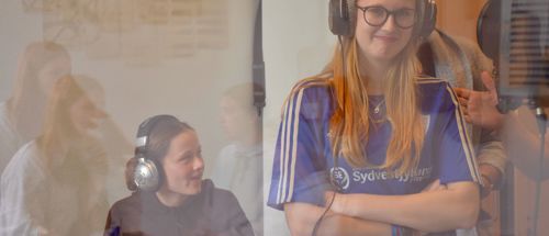 En pige står med hørebøffer på i lydstudiet på Sædding Efterskole