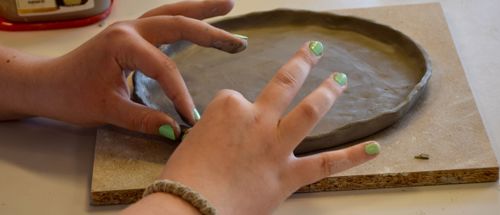 Pige former ler til en tallerken i kunst og design på Sædding Efterskole 