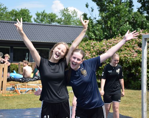 To piger efterskolepiger spreder begejstret armene i vejret i Sædding Efterskoles have