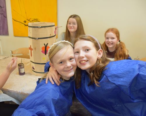 Elever og søskende maler på en fastelavnstønde på Sædding Efterskole til årets søskendeweekend.