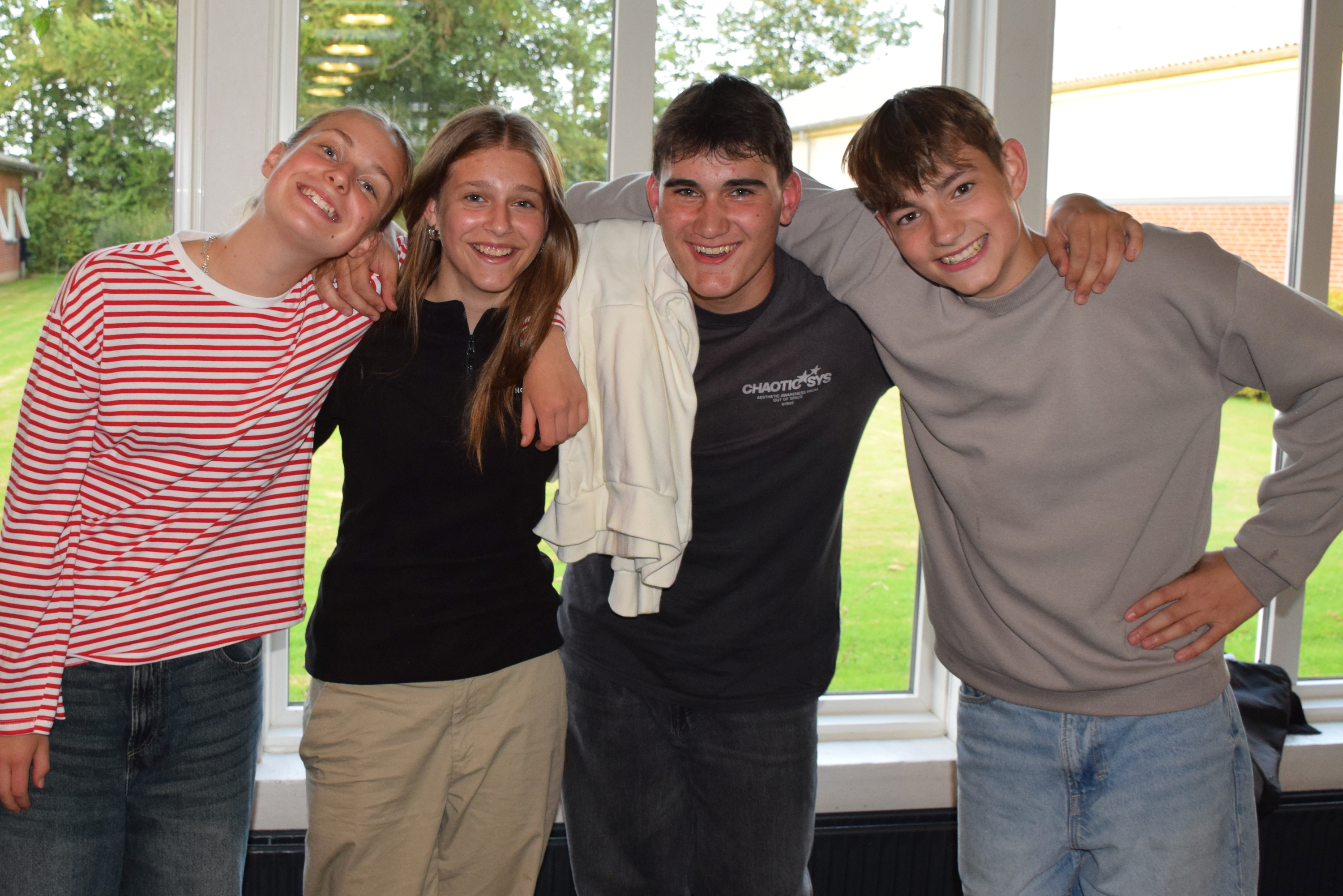 Valgfag Sædding Efterskole - 4 elever står smilende med armene om hinanden. 