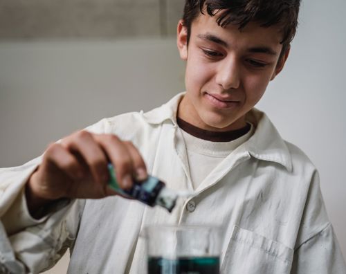 Science på Sædding Efterskole | Efterskoleelev blander væsker i fysik på Sædding Efterskole