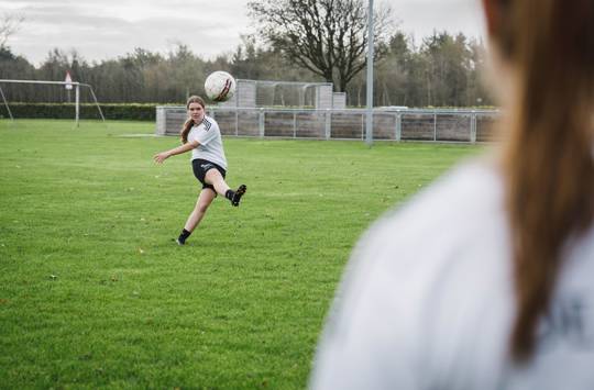 Efterskolepige giver fodbolden et ordentligt spark, så den flyver højt