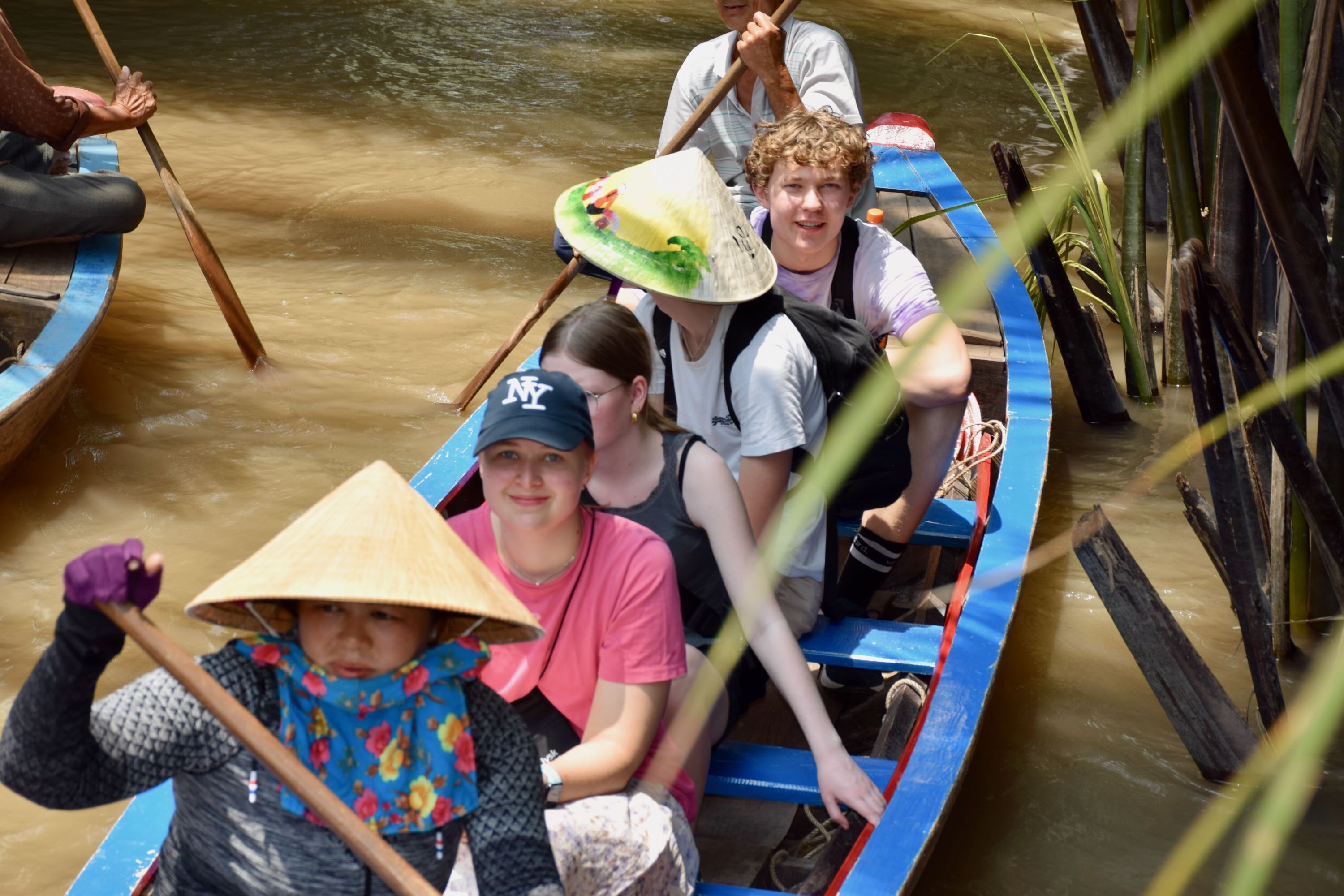 Elever fra Sædding Efterskole er ude at sejle på en flod med. En vietnamesisk kvinde ror. 