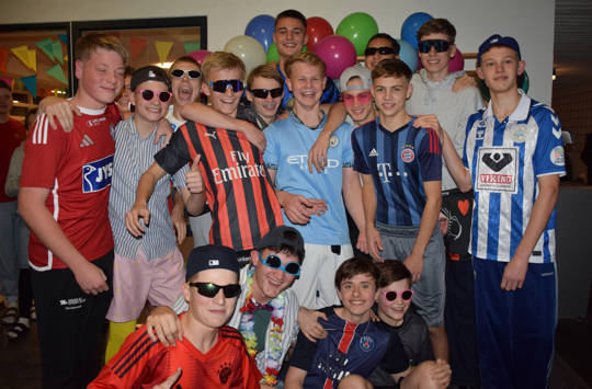 Efterårets temafest på Sædding Efterskole var børnefødselsdag. Her ses en flok drenge foran billedvæggen.