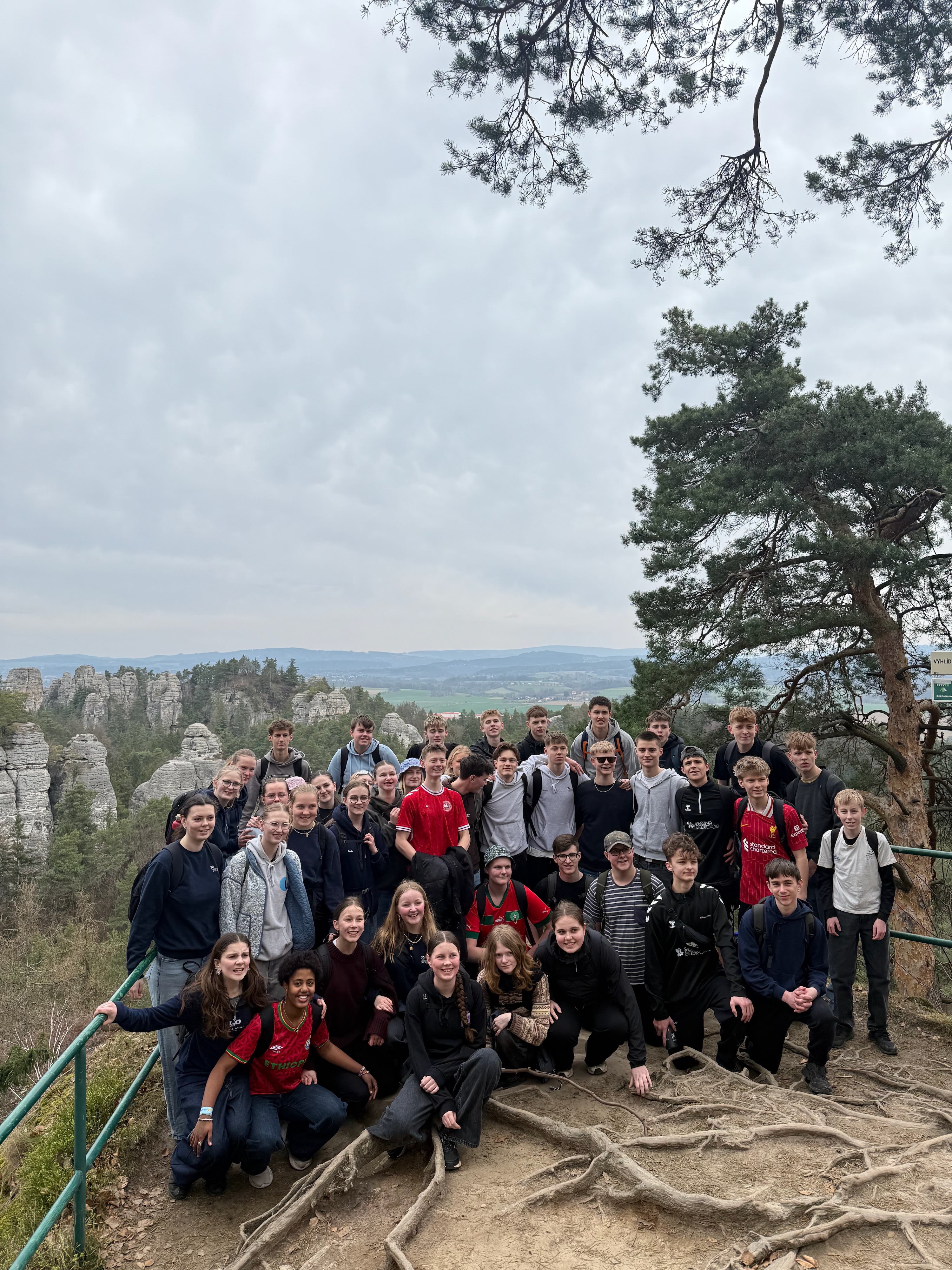 En stor gruppe af elever fra Sædding Efterskole er fotograferet ved et udsigtspunkt på en vandretur i Tjekkiet. 