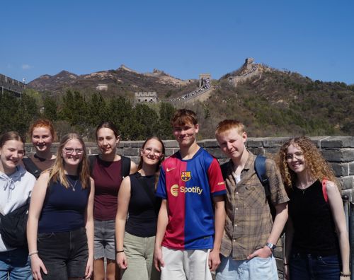En flok glade elever fra Sædding Efterskole står på Den kinesiske mur i Kina