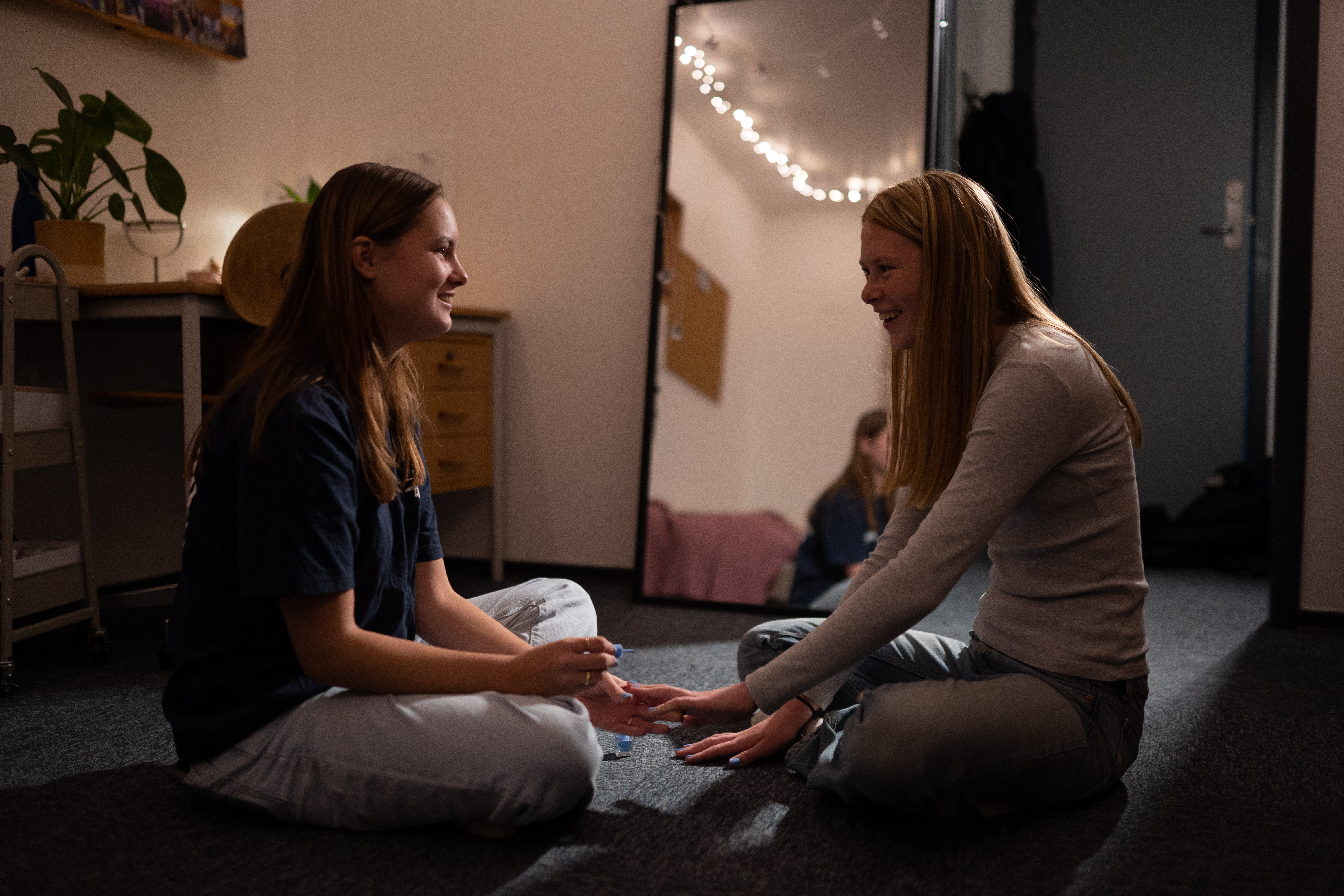 Efterskolernes dag. To piger sidder på gulvet på deres værelse på Sædding Efterskole og lægger neglelag - mens de smiler til hinanden. 