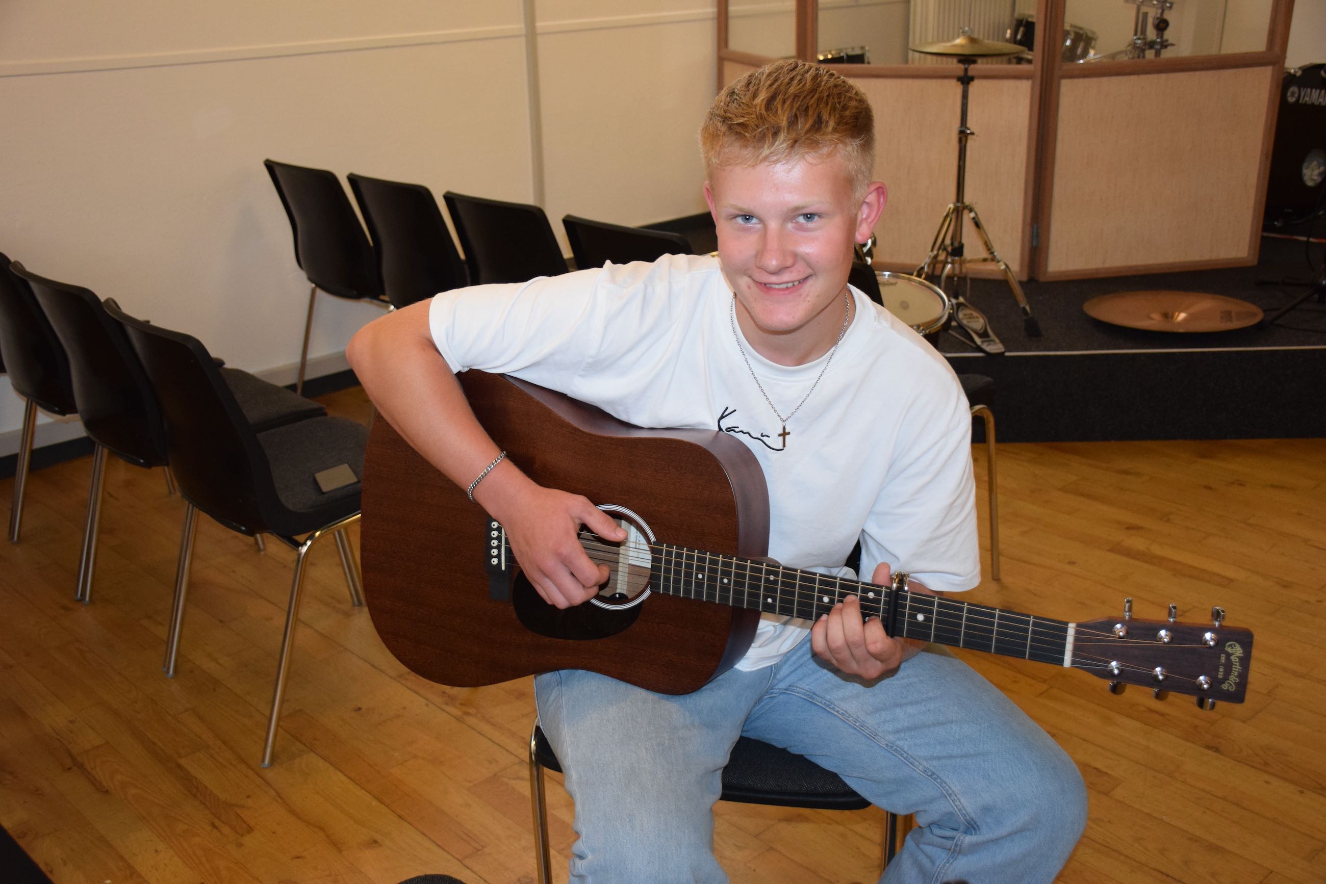 Efterskoleelev spiller akustisk guitar